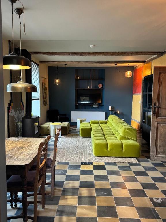 a living room with green furniture and a checkered floor at L' Ecole in Durbuy