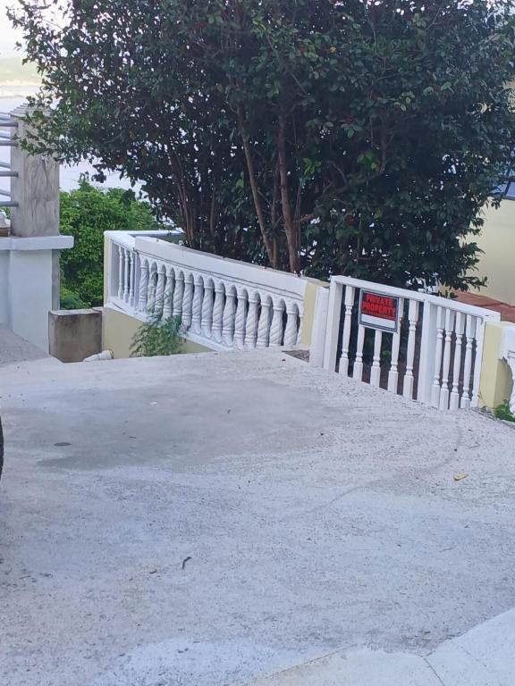 a white fence with a sign on it at Yellow Leaf Suite in West End