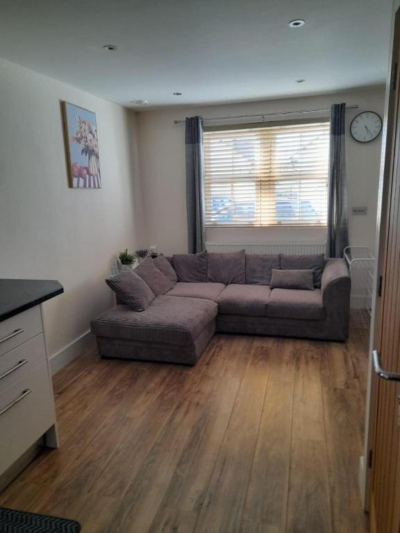a living room with a couch and a window at Comfort Horizon Egham in Egham