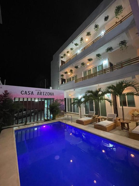 a swimming pool in front of a building at night at Casa Arizona in Brisas de Zicatela