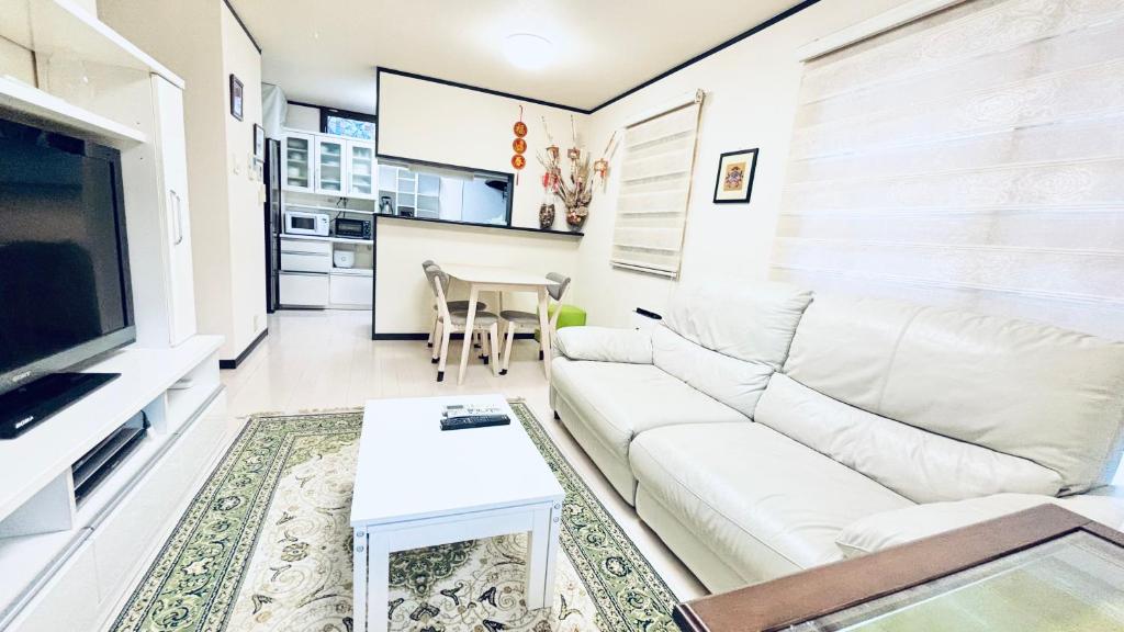 a living room with a white couch and a table at Direct to every spots 4mins to station 4Lines for used Big House Family Direct Shinjuku Ikebukuro 3 Bedrooms Max for 8 people in Tokyo