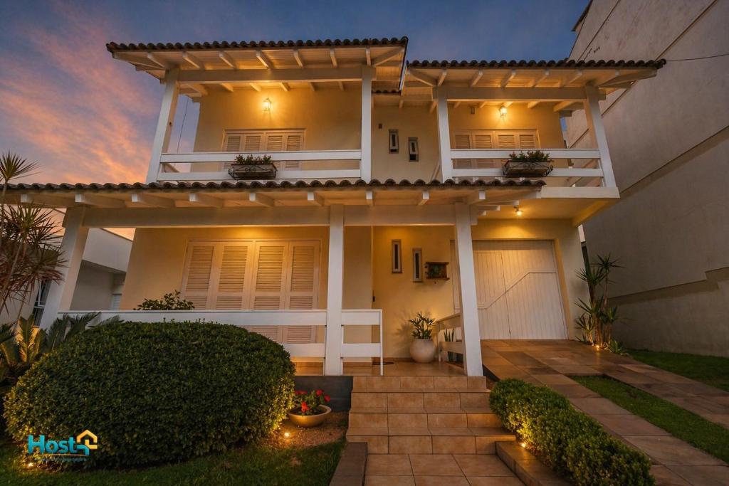 a house with a lit up facade at night at Casa grande e aconchegante in Encantado