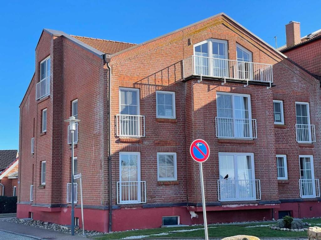 a red brick building with a sign in front of it at Ferienwohnung in Orth auf Fehmarn in Orth