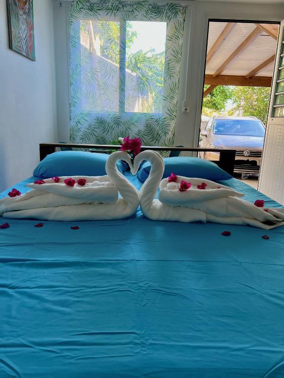two swans made out of towels on a bed at Instant Locatif in Gourbeyre
