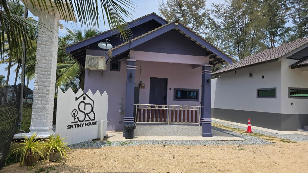 a small purple house with a palm tree at SR Tiny House in Bachok