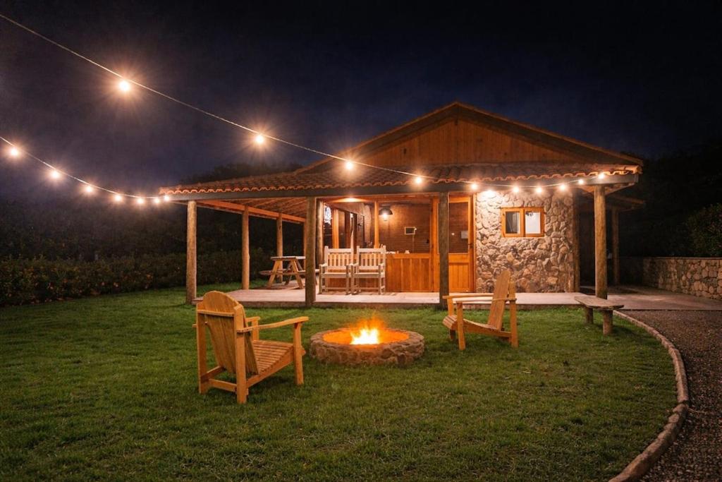 a cabin with a fire in the yard at night at Cabana do Sol -São Francisco Xavier in São José dos Campos