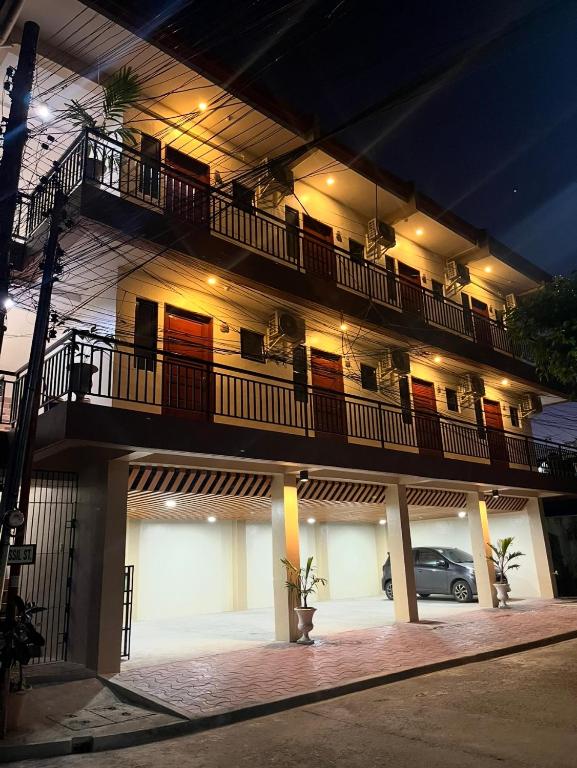 a building with balconies and a car parked in front of it at Studio apartment in Mactan,Cebu-Room201 in Mactan
