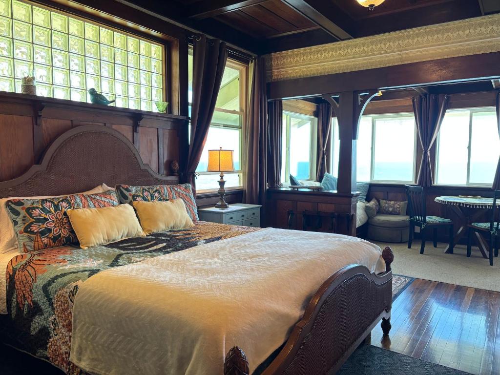 a bedroom with a large bed in a room with windows at Hilo Bay Oceanfront Bed and Breakfast in Hilo
