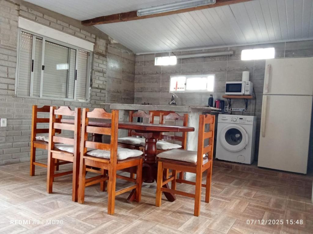 a kitchen with a table and chairs and a refrigerator at BRISAN descanso sol,y playa in Barra del Chuy