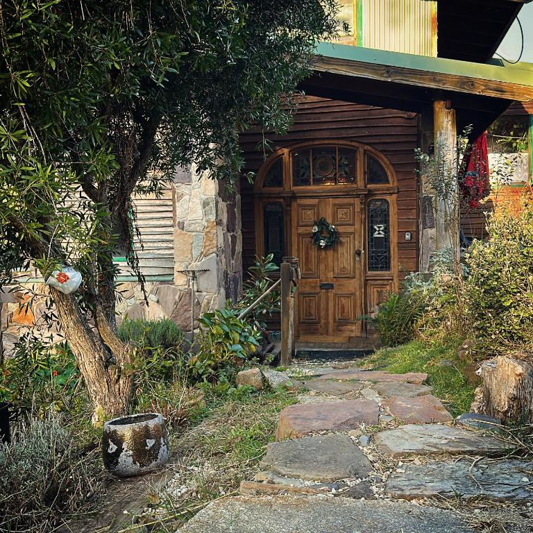 a wooden door of a house with a stone walkway at CIRQUE 5 - Alpine Lodge built around a ski lift tower in Merrijig
