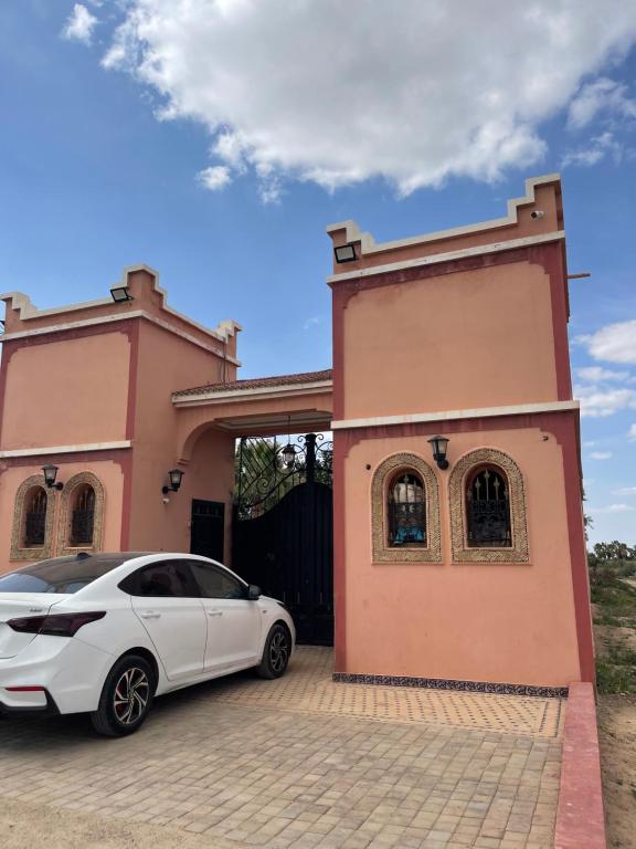 a white car parked in front of a house at Route Agafay in Aït Ali