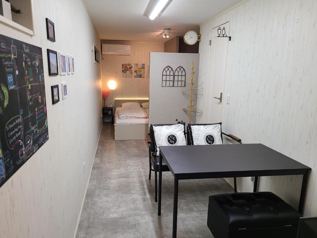 a room with a table and chairs and a bedroom at Greci Art Tokyo グレーチアート東京 in Tokyo