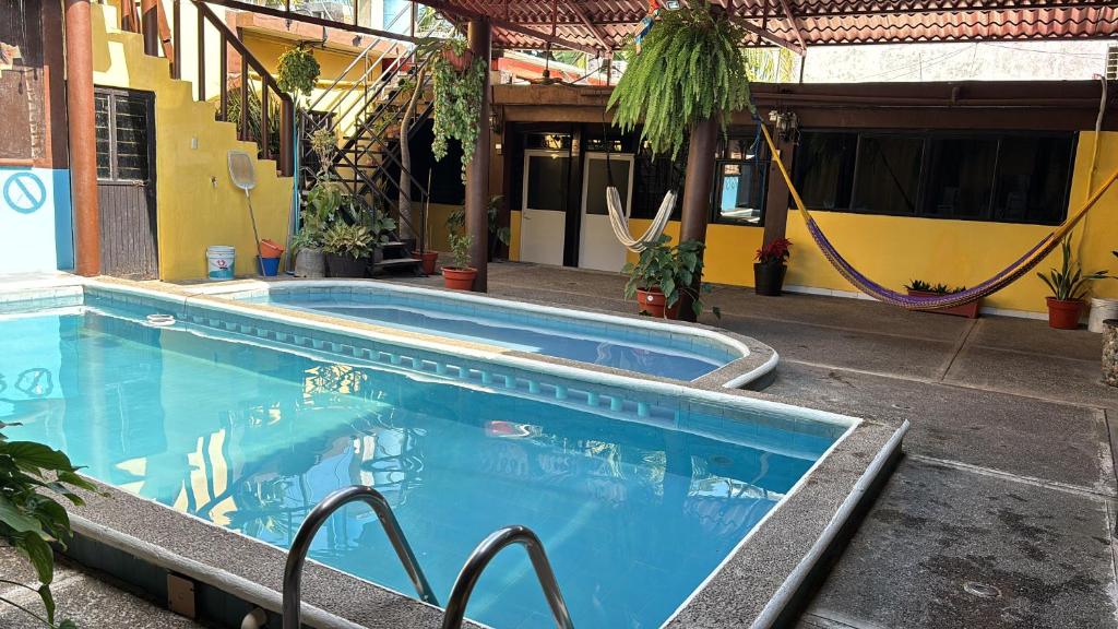 a large swimming pool next to a building at Hotel Luxi in Playa Azul