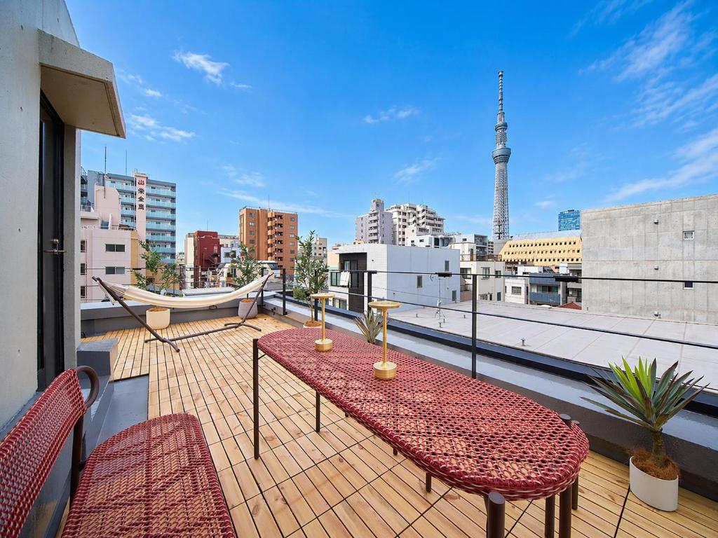 a balcony with a table and chairs and a view of a city at TOMARIE Rooftop House Skytree in Tokyo