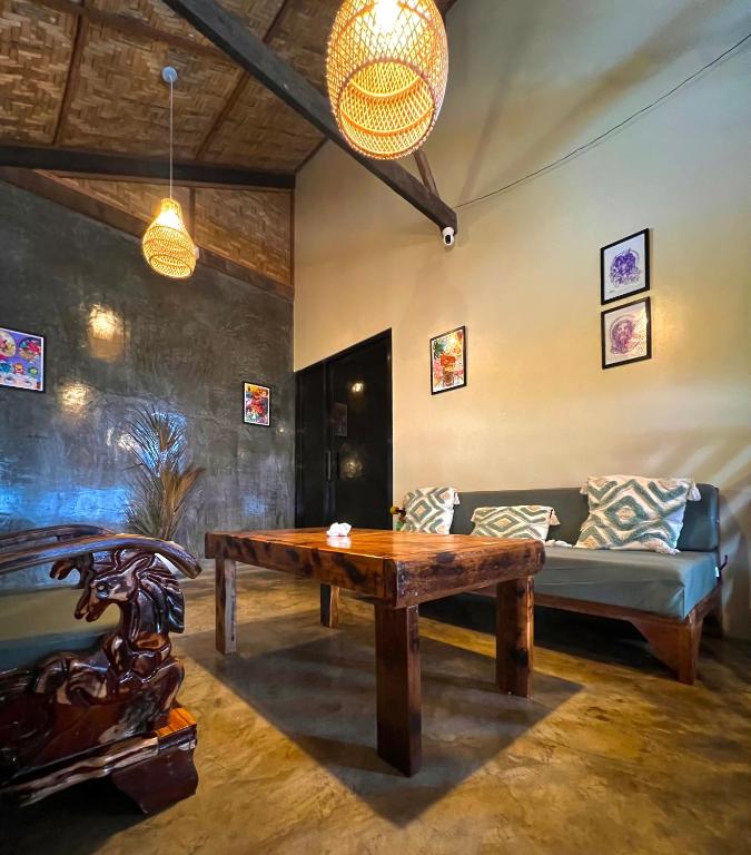 a living room with a table and a couch at Ginhawa Stay Mixed dorm 6 Bed in Burgos