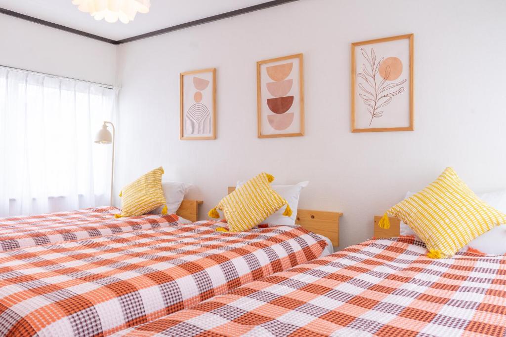 two beds sitting next to each other in a bedroom at Lino下伊福 in Okayama