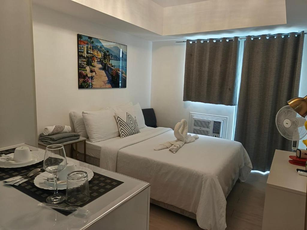 a hotel room with two beds and a couch at M&R Condotel Azure North in San Fernando