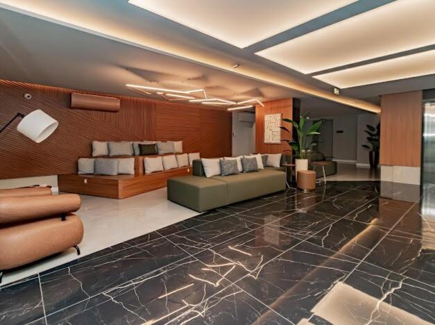 a lobby with a couch and chairs in a building at Studio 208 Premium 450m do Consulado EUA in Porto Alegre