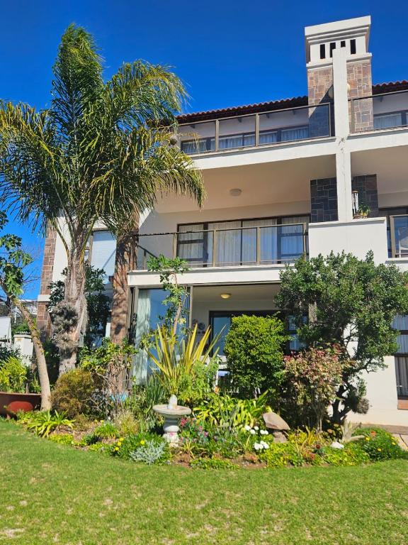 an exterior view of a building with palm trees at Marine View in Plettenberg Bay