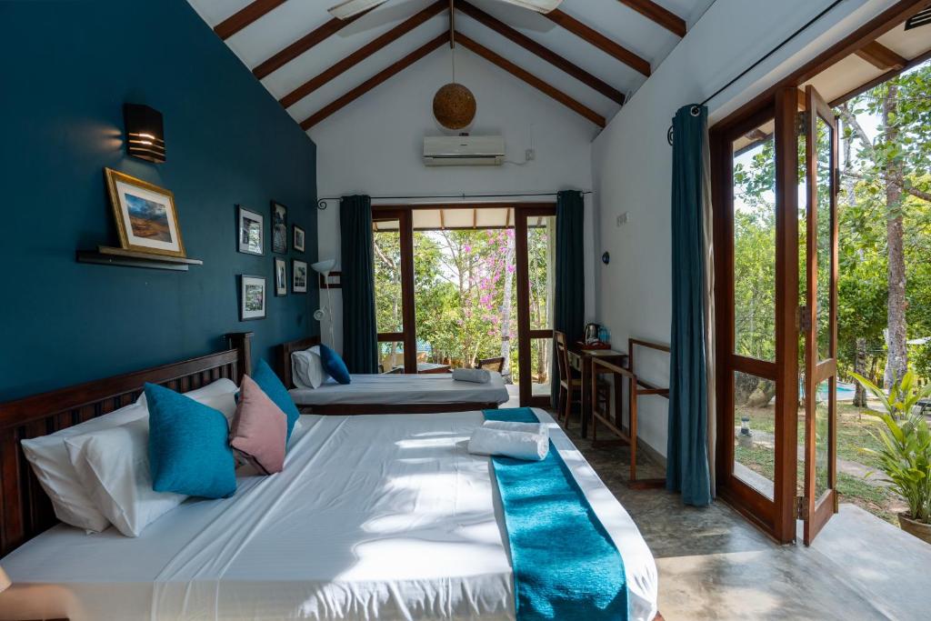 a bedroom with a large bed with blue walls at Ecoya Riverside Resort in Balapitiya