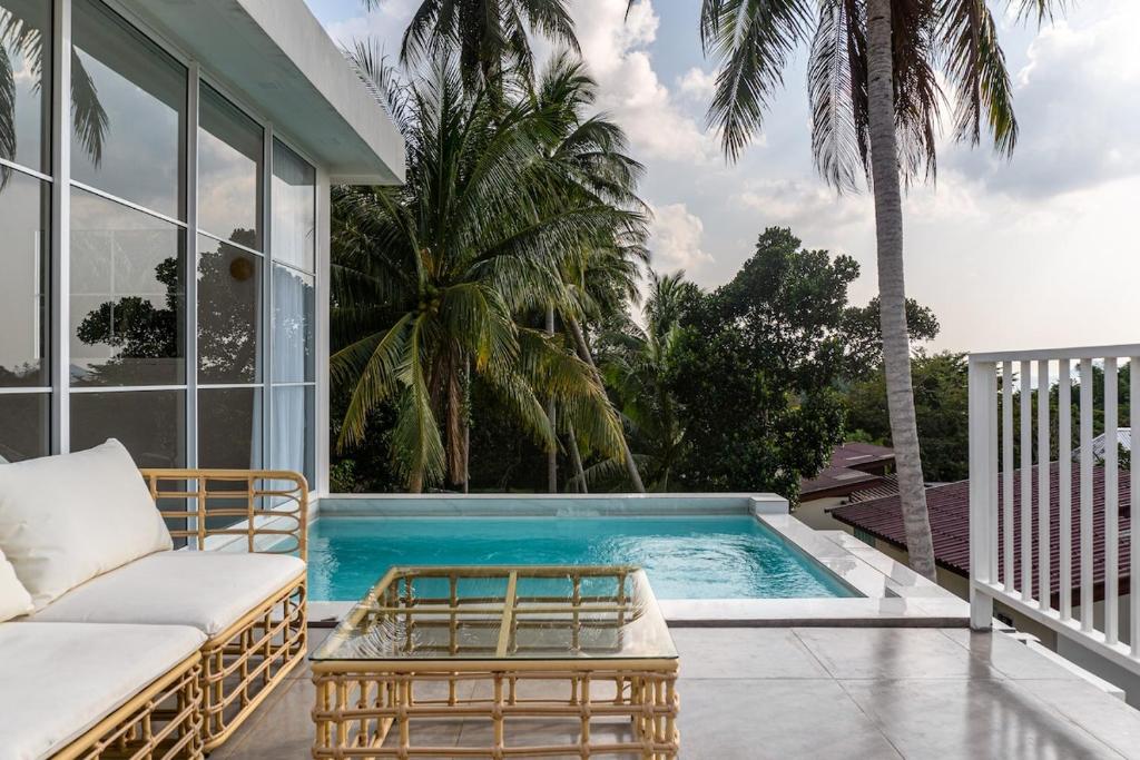 a villa with a swimming pool on a patio at Blue Garden Villa A in Ban Madua Wan