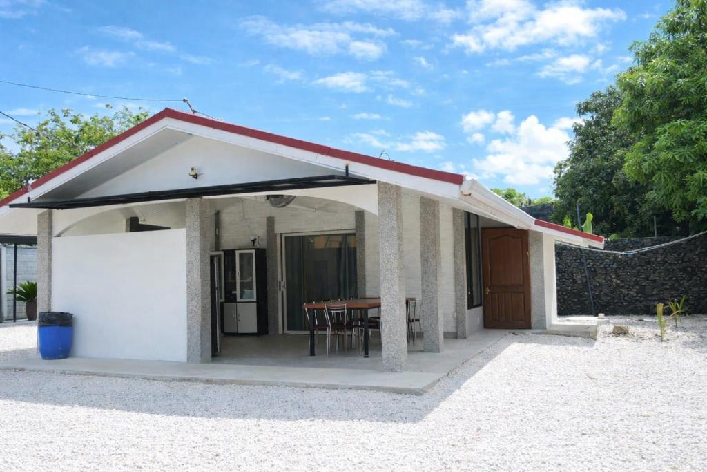 a small house with a red roof and a table at Conchal Maquito House in Brasilito