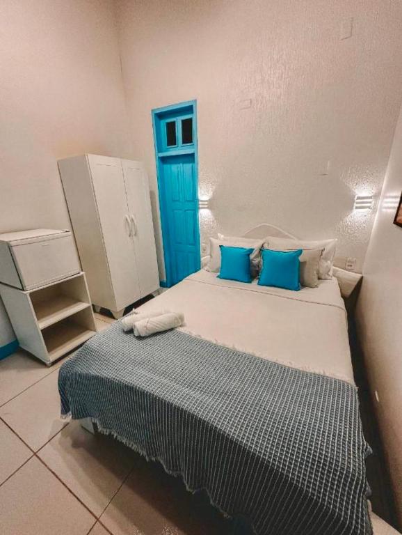 a small bedroom with a bed with blue accents at Pousada Vila dos Piratas in Jericoacoara