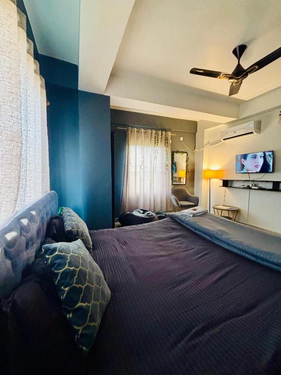 a bedroom with a large bed with a ceiling fan at Serene Cove Homestay in Dispur
