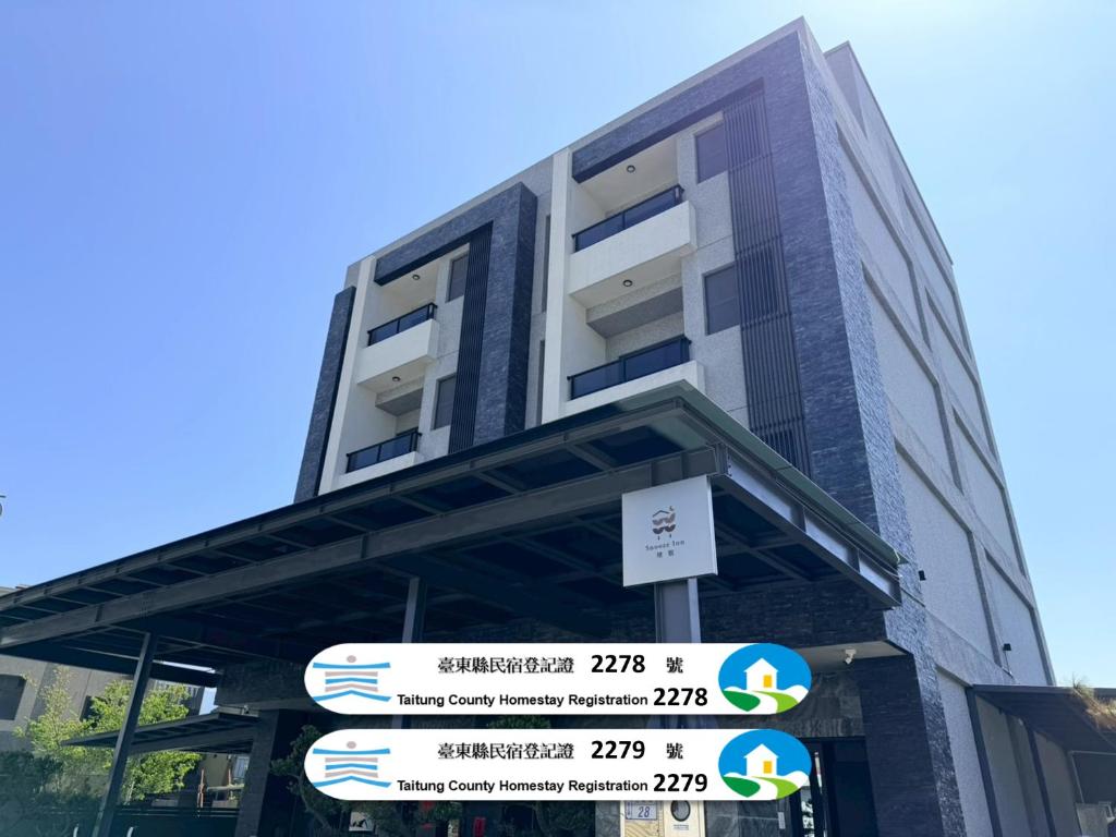 a tall building with street signs in front of it at 穗眠民宿SnoozeInn in Chishang
