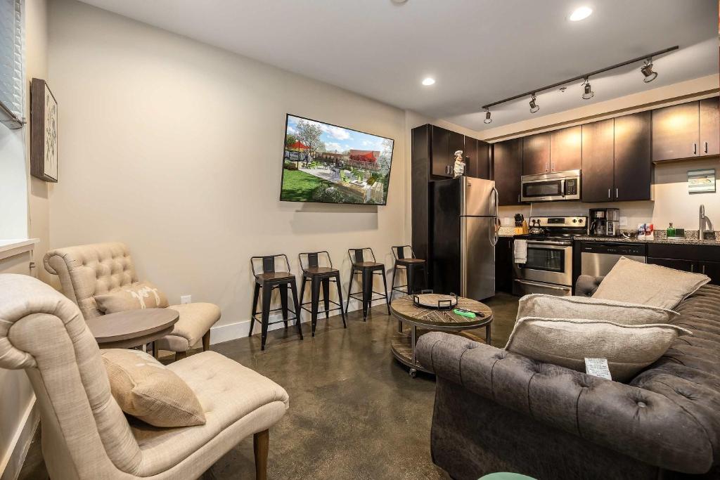 a living room with couches and chairs and a kitchen at The West End Flats Hotel in Roanoke