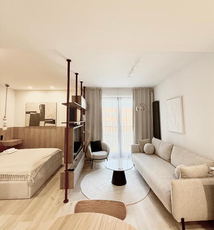 a living room with a couch and a bed in a room at Luxury Art Apartment Wrocław in Wrocław
