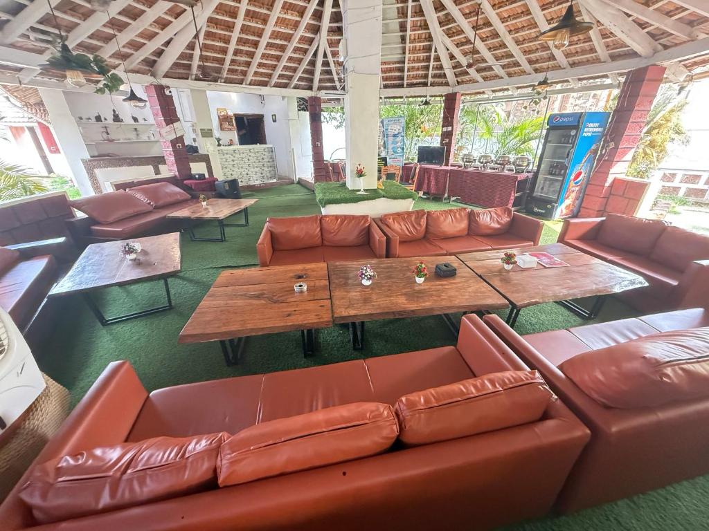 a living room with leather couches and tables at RnB Beach Resort in Anjuna