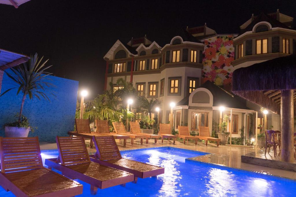 a resort with a swimming pool at night at Pousada Castello Montemare in Ubatuba