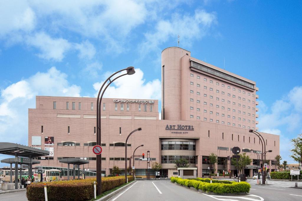 duży budynek z światłem ulicznym przed nim w obiekcie Art Hotel Hirosaki City w mieście Hirosaki