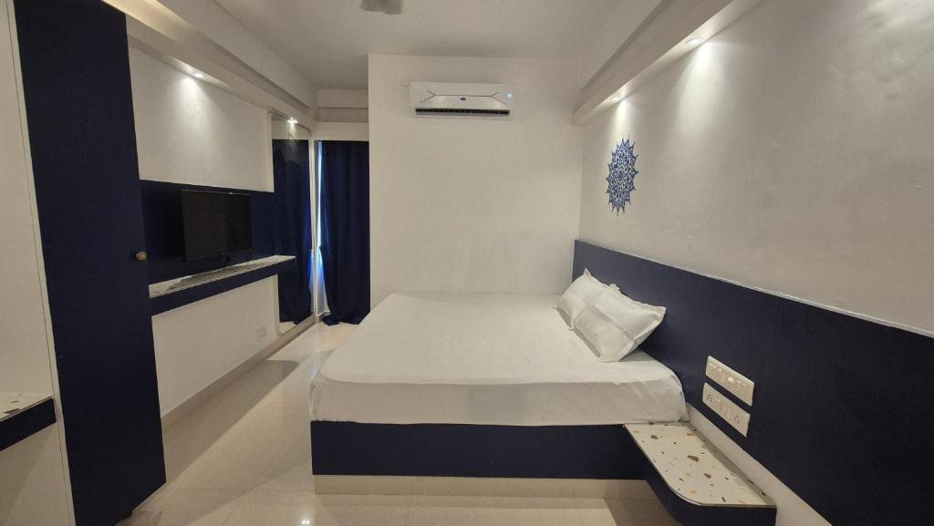 a small room with a bed and a tv at BLEU by NIRVANA in Mahabalipuram