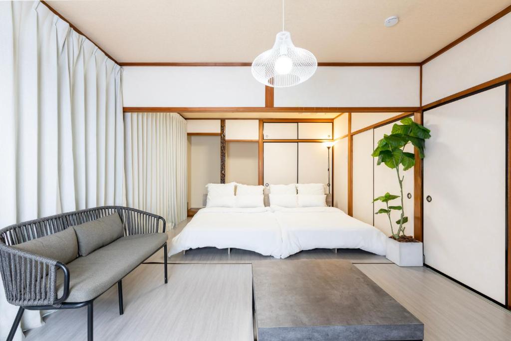 a bedroom with a bed and a couch at gently stay Nagoya in Nagoya