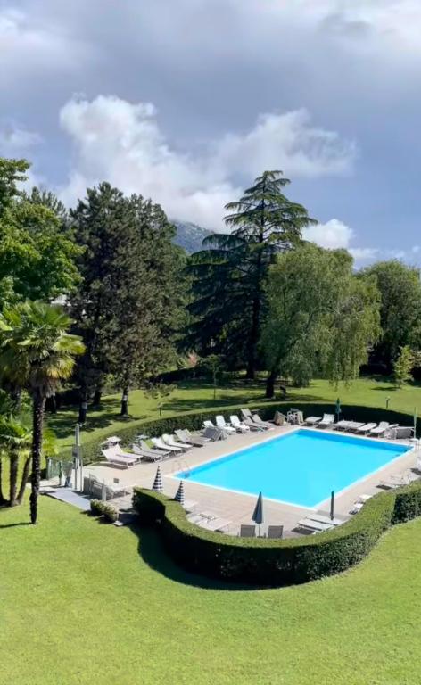 a large swimming pool with lounge chairs around it at Cosy in the Park quiete e relax in un'oasi verde in Como