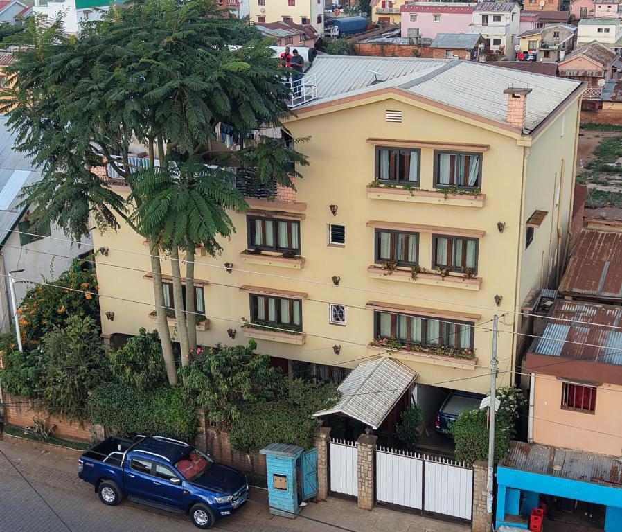 a blue car parked in front of a building at Antsirabe Hotel in Antsirabe