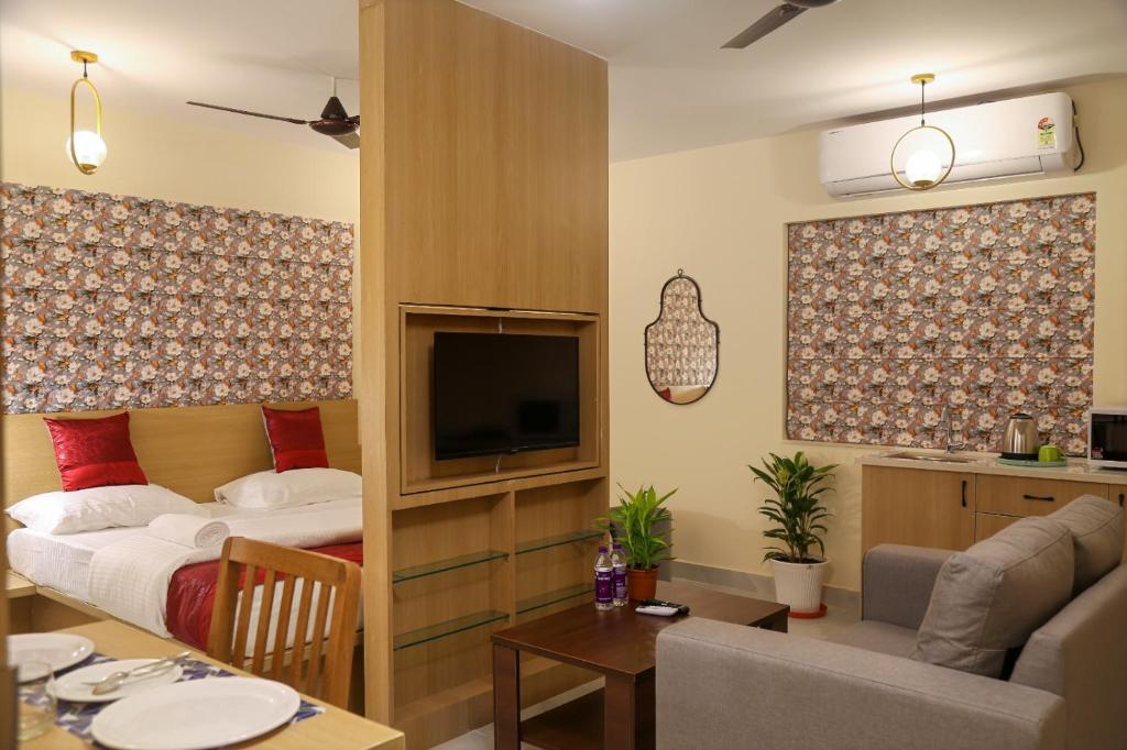 a hotel room with a bed and a living room at Lumis studio apartment in Hyderabad