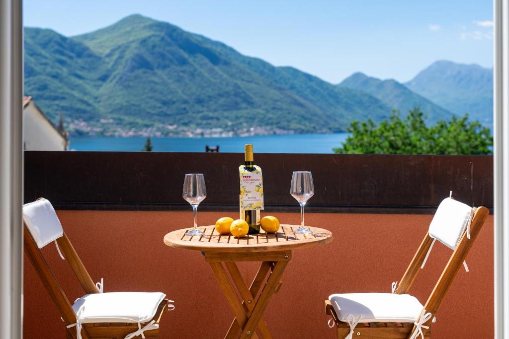 a table with a bottle of wine and two glasses at Radonjić Apartments in Kotor