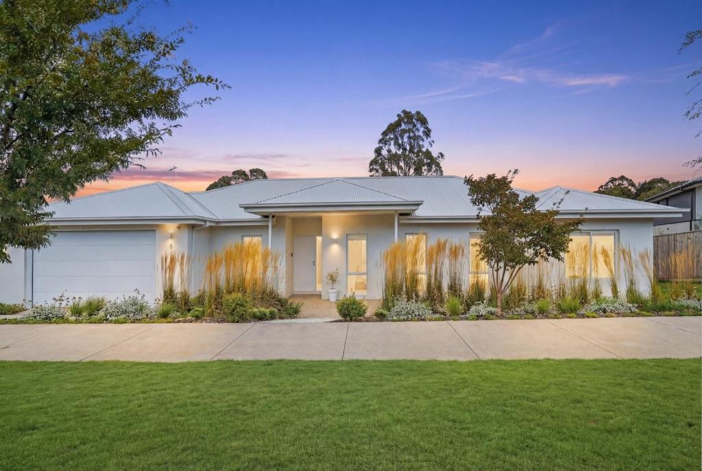 a large white house with a grass yard at Centella House in Korumburra
