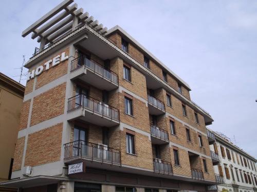 a large brick building with a hotel sign on it at Hotel Traghetto in Civitavecchia