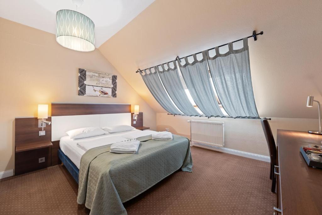 a bedroom with a bed and a large window at Boulevard City Panzió - self check-in in Budapest