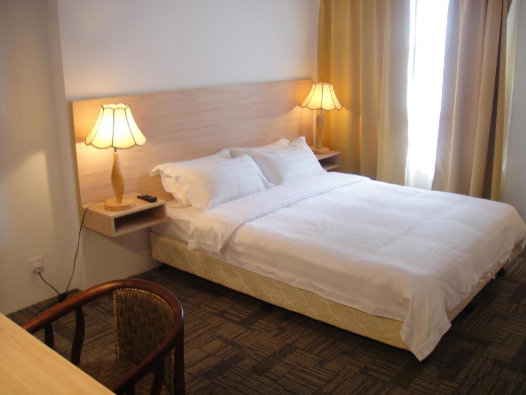 Postel nebo postele na pokoji v ubytování Prima Hotel Melaka