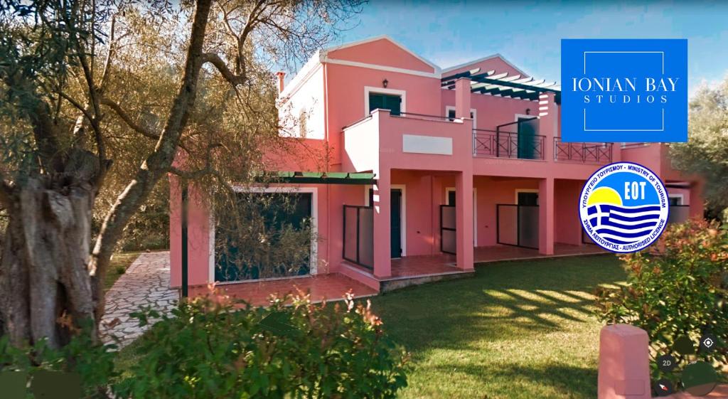 a pink house with a sign in front of it at Ionian Bay Studios in Lefkada