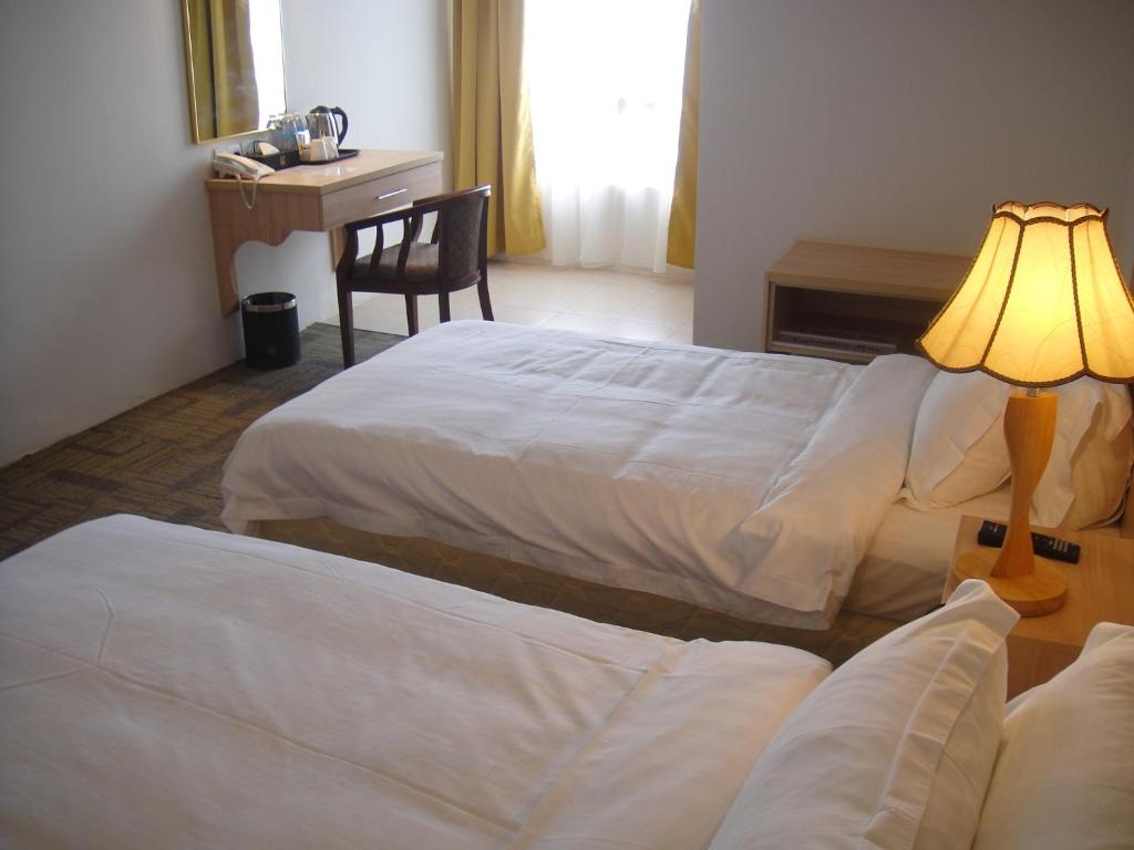 Postel nebo postele na pokoji v ubytování Prima Hotel Melaka