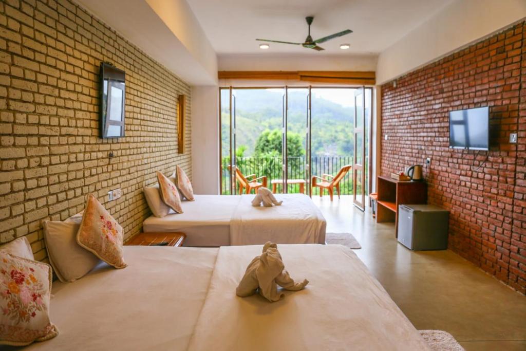 a bedroom with two beds and a brick wall at Hillcrest Ella in Ella