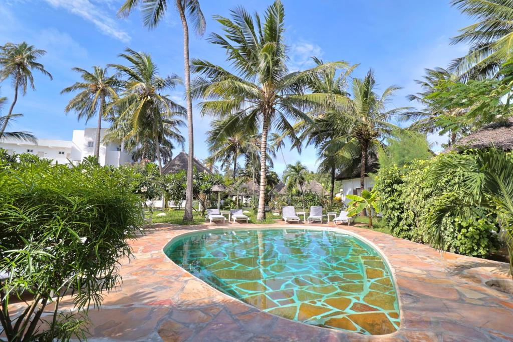 a swimming pool in a resort with palm trees at Watamu Ascot Residence in Watamu
