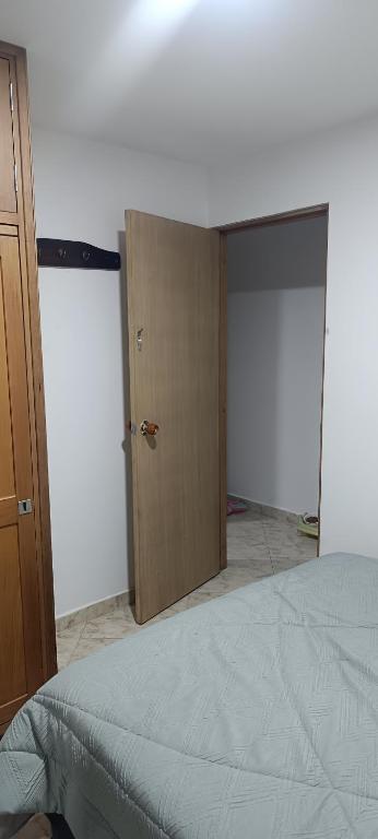 a bedroom with a bed and a closet and a door at Habitación in Itagüí