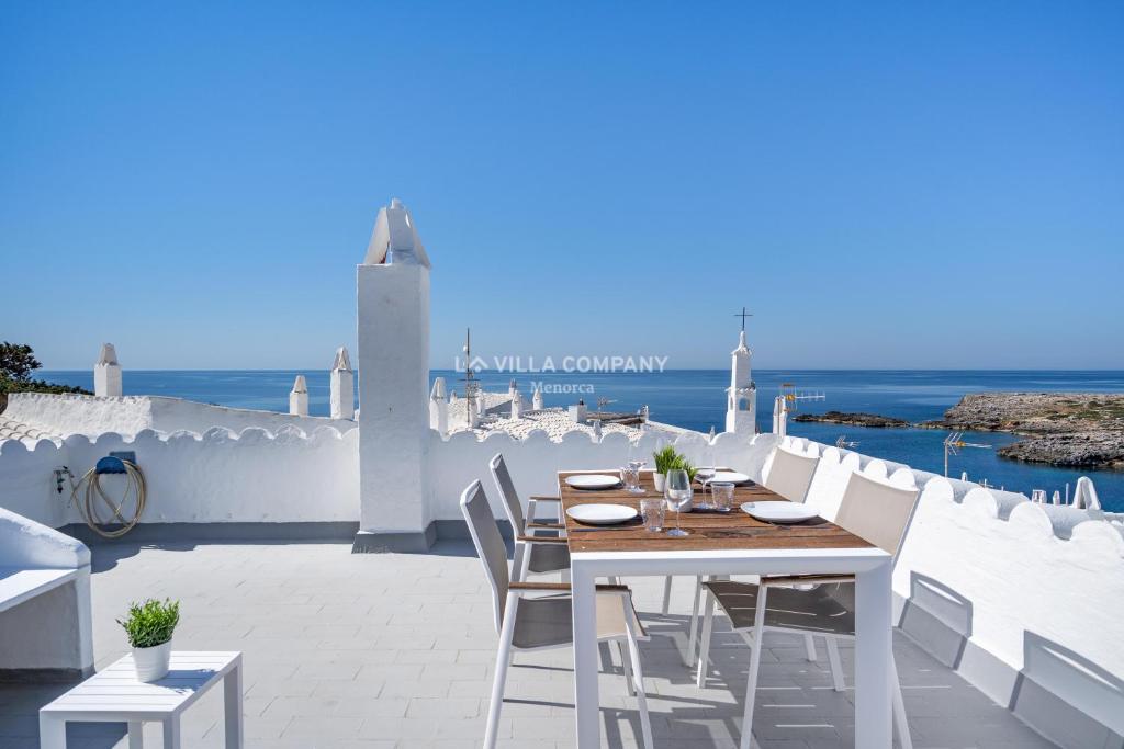 a table and chairs on a patio with the ocean at Apartment BINIBECA 60 in Binibeca
